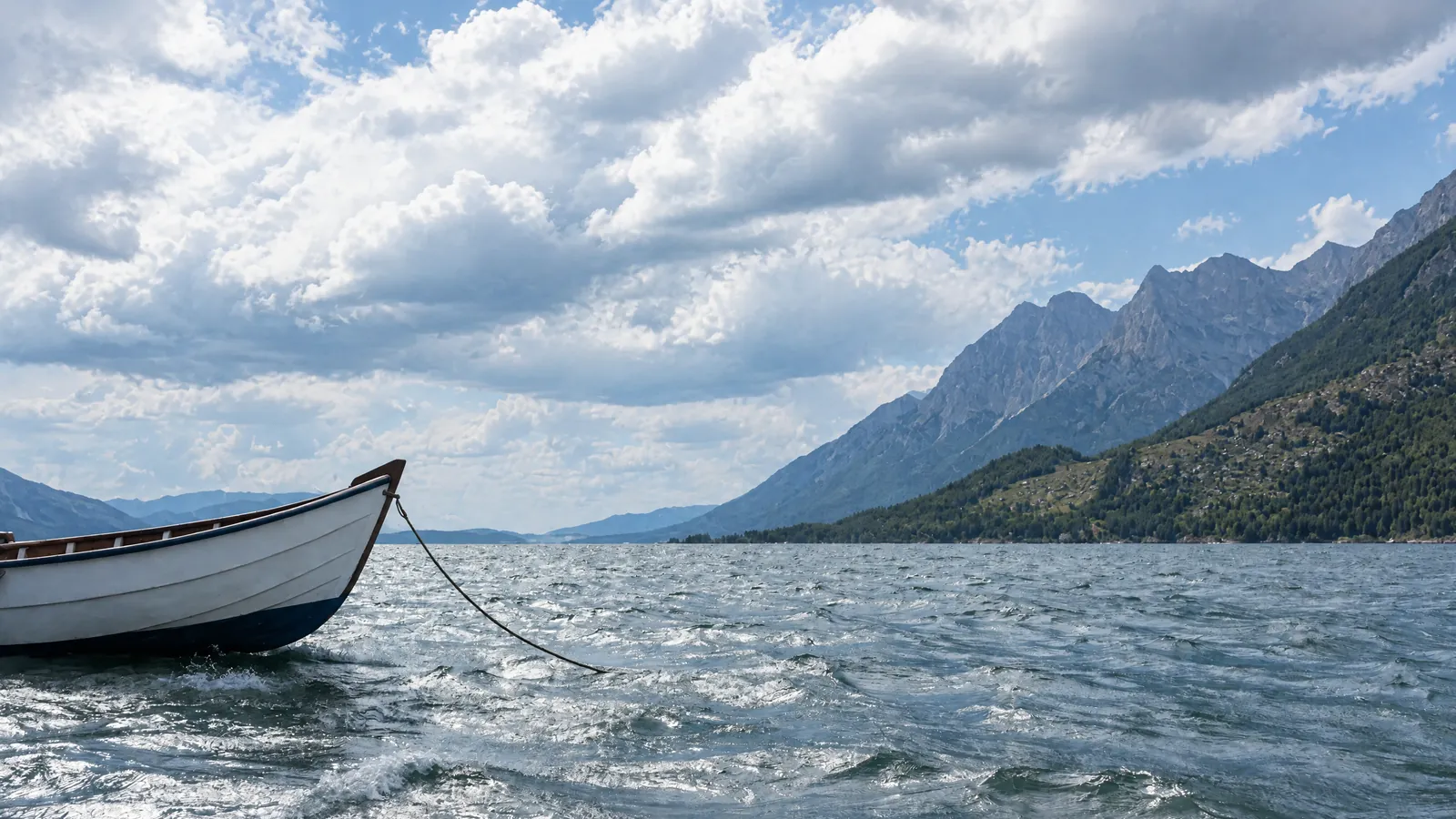 Gewitterwolken über einem Alpensee mit vertäutem Boot