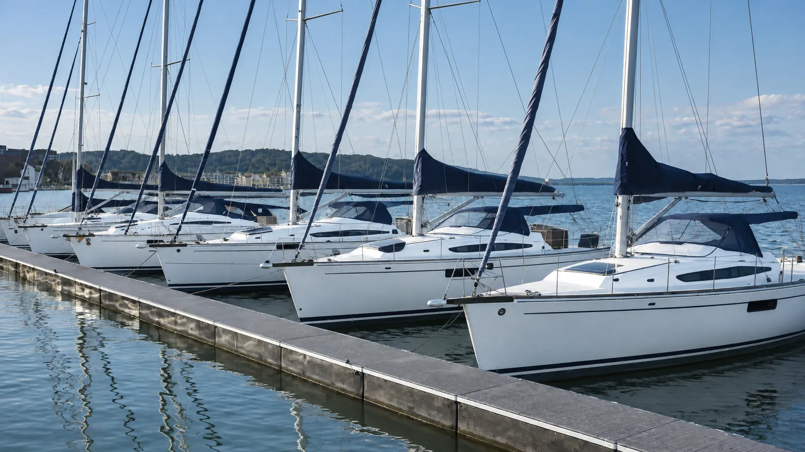 Segelyachten derselben Bauart nebeneinander am Steg