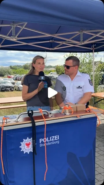 Ein Beamter der Wasserschutzpolizei Brandenburg beim Interview neben dem Graviertisch im Freien