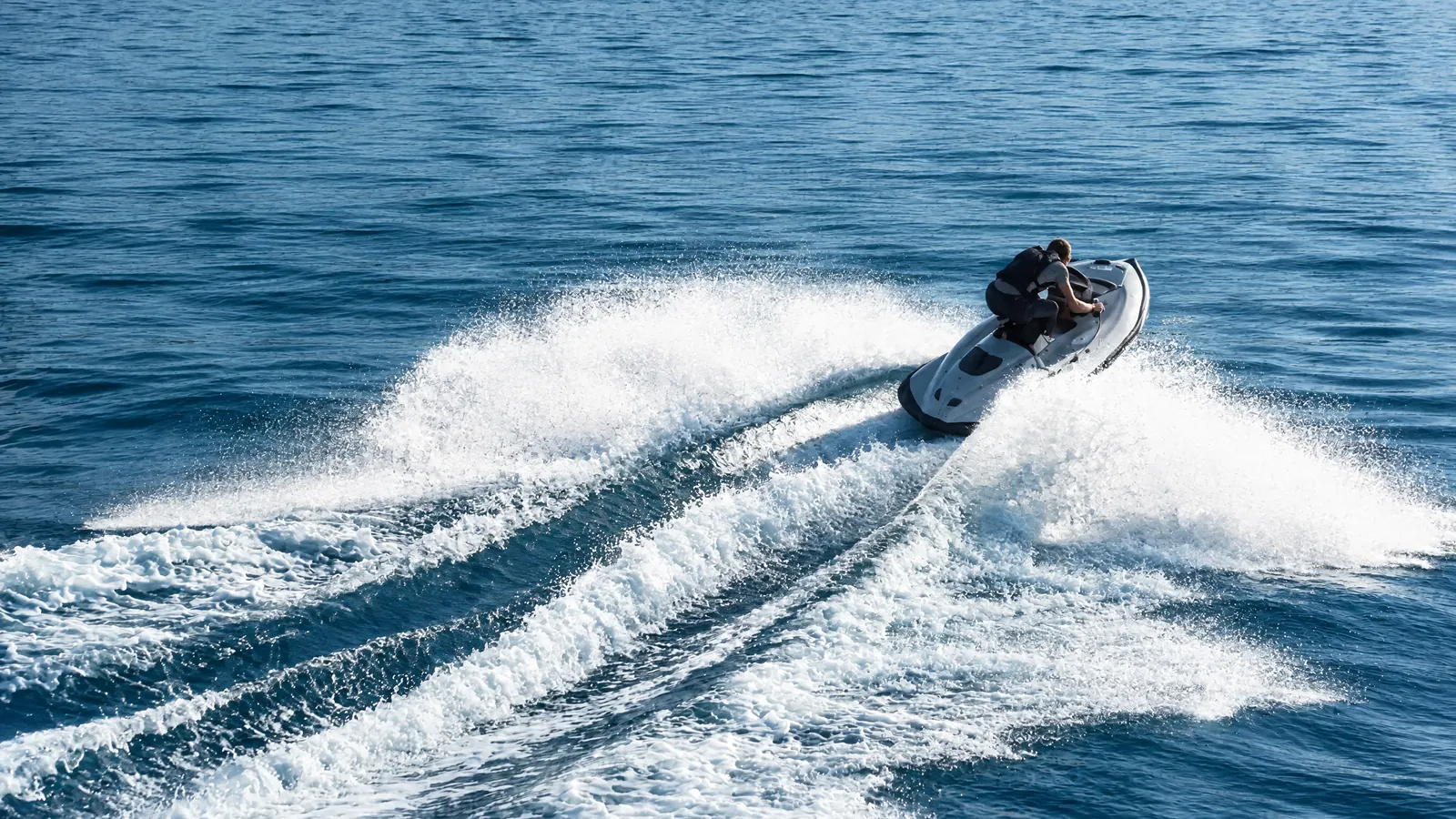 Jetski in der Kurve mit Gischtfahne