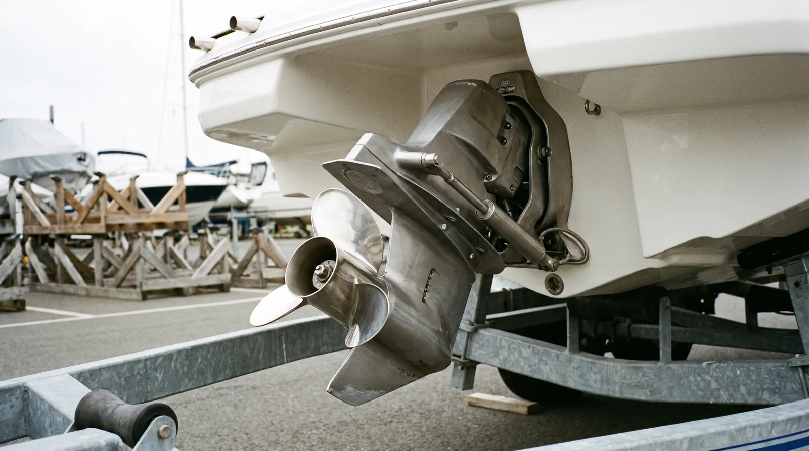 Hochgeklappter Z-Antrieb mit Propeller eines kleinen Motorboots an Land, ein Propellerblatt ist verbogen.