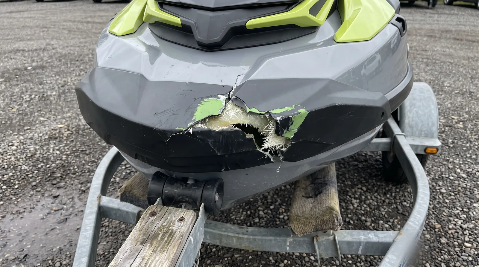 Bug eines weißen Jetskis auf dem Trailer mit Riss und abgeplatztem Gelcoat nach einem Anprall.
