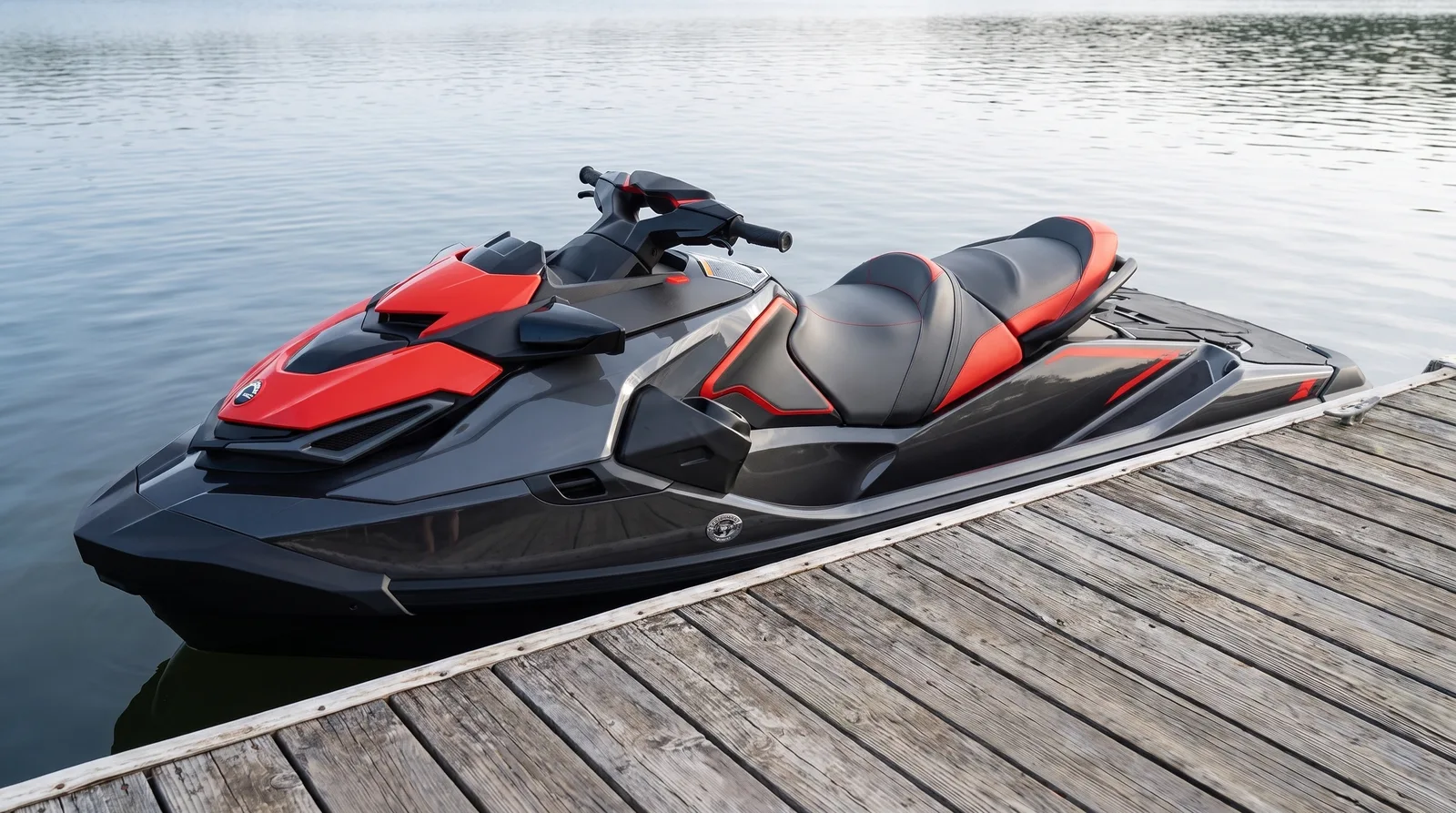 Moderner schwarz-grauer Tourenjetski mit roten Akzenten am Holzsteg eines Sees.
