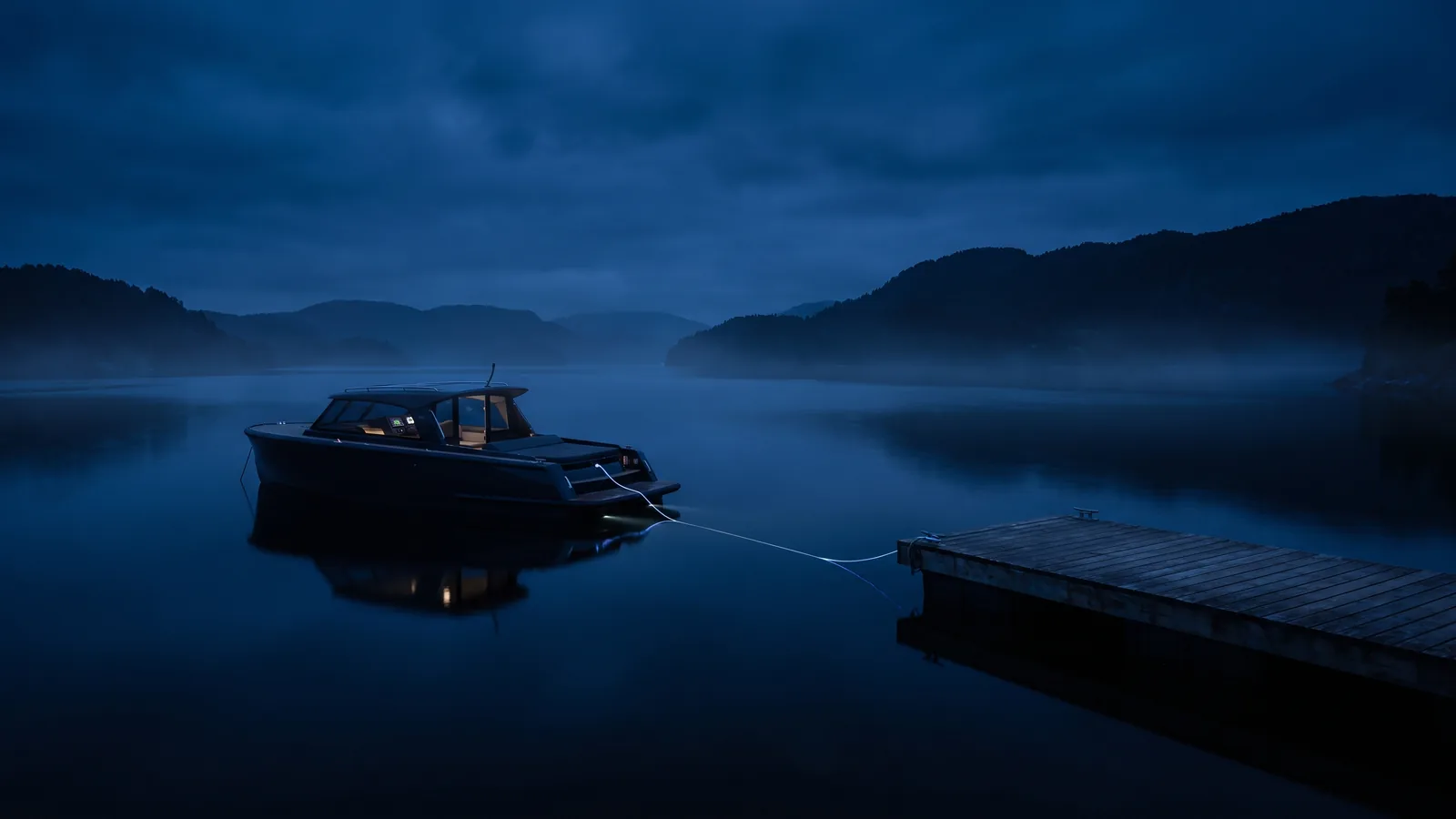 Ein Elektroboot zieht lautlos über einen stillen Alpensee, am Steg liegt das Ladekabel