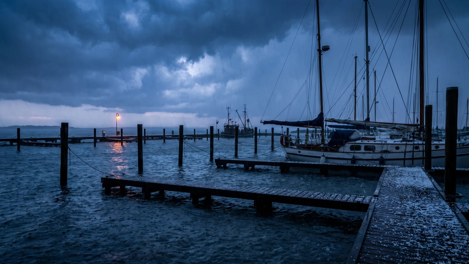 Marina bei Sturm in der Dämmerung, das Wasser steht über den Stegen