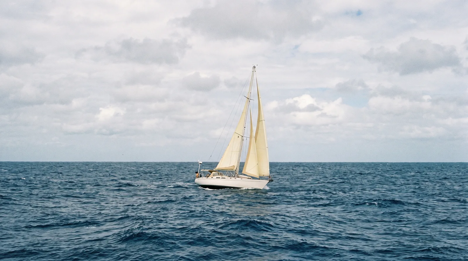 Segelyacht unter Segeln allein auf dem offenen Meer, kein Land am Horizont