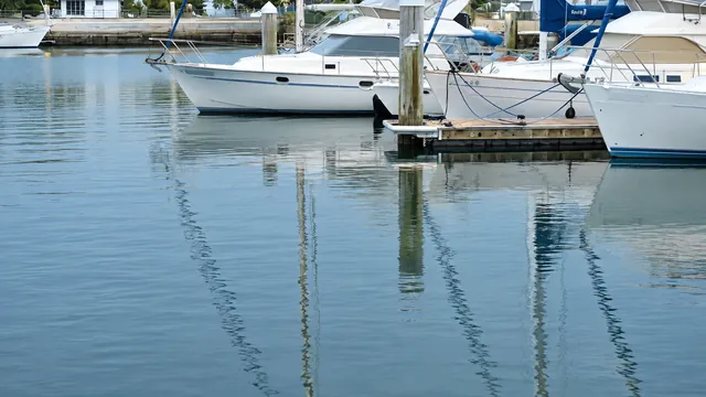 Ein stiller Yachthafen bei Tag, die Stege spiegeln sich im glatten Wasser